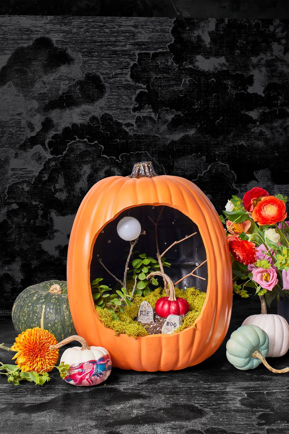Orange pumpkin with a spooky grave scene set up inside, creating a Halloween-themed decoration